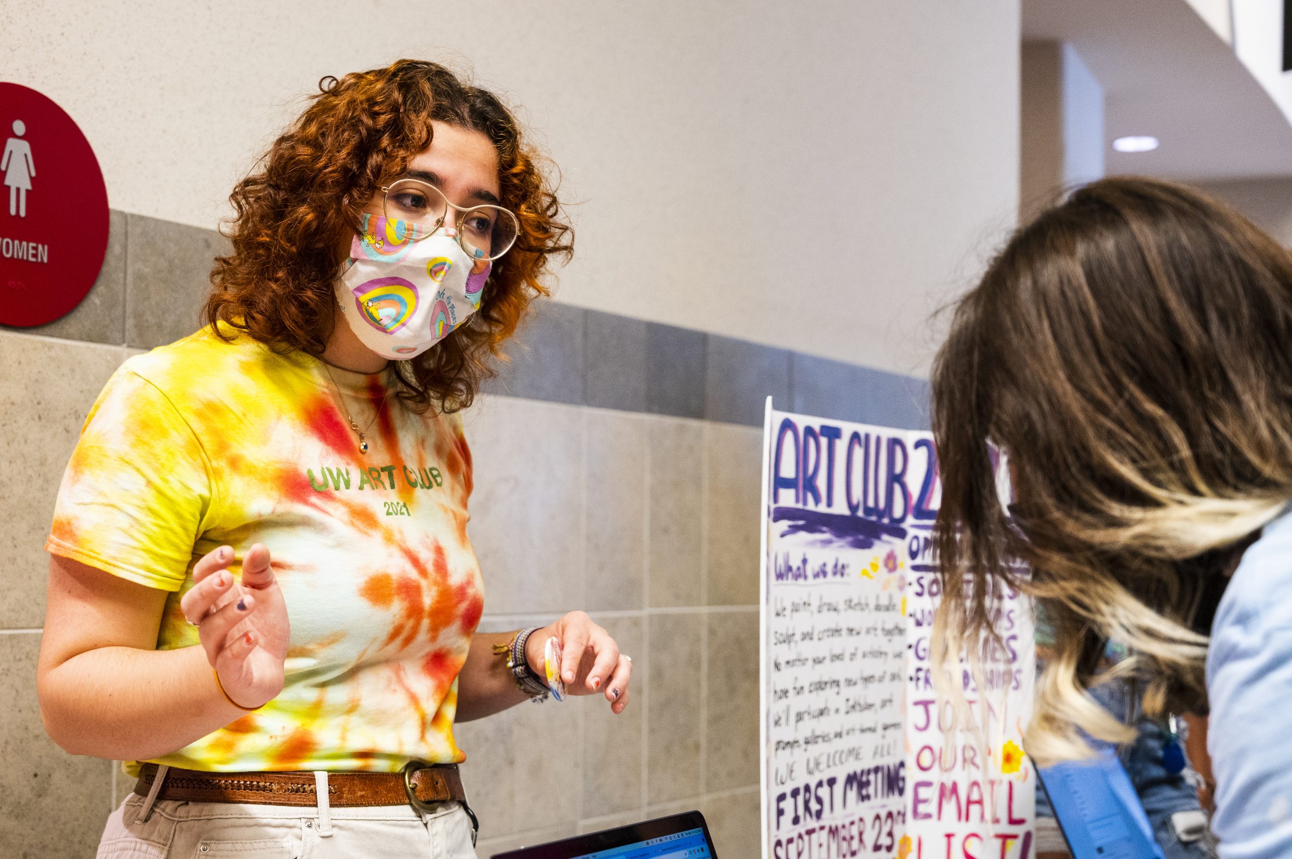 Woman with a mask looks at another person