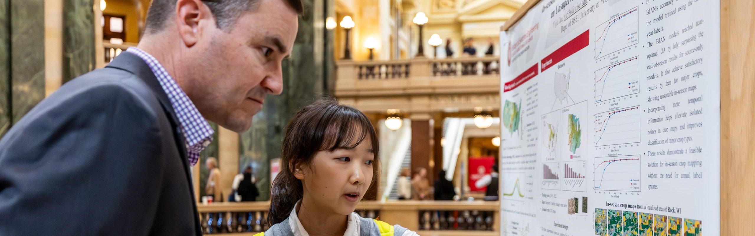 Two people look at an informational poster